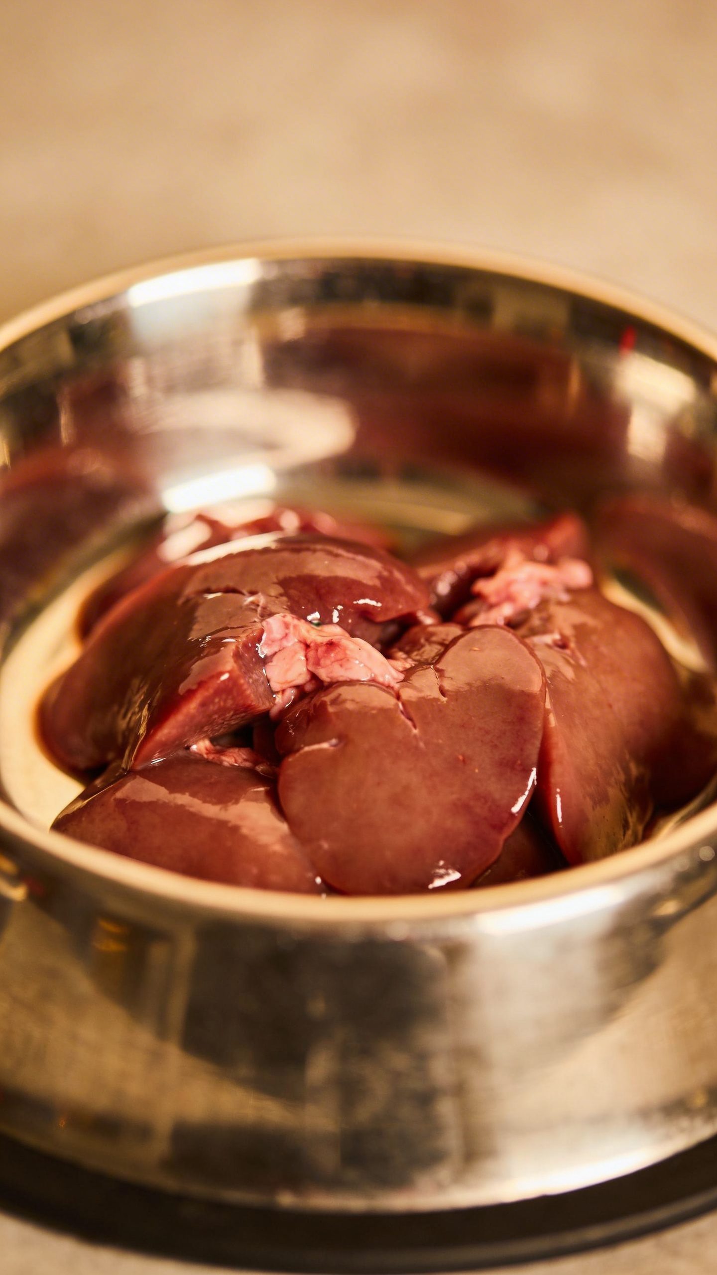 Fresh chicken liver pieces in stainless dog bowl