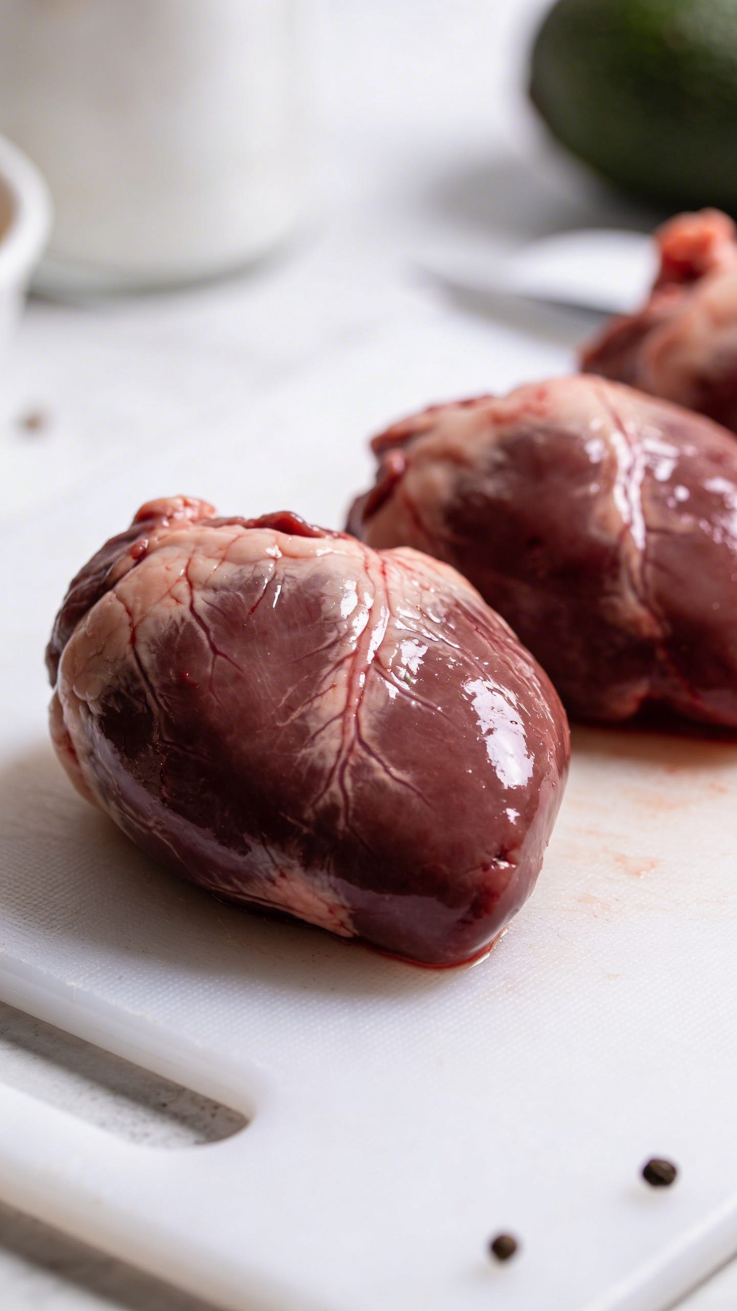 Raw chicken liver on white cutting board