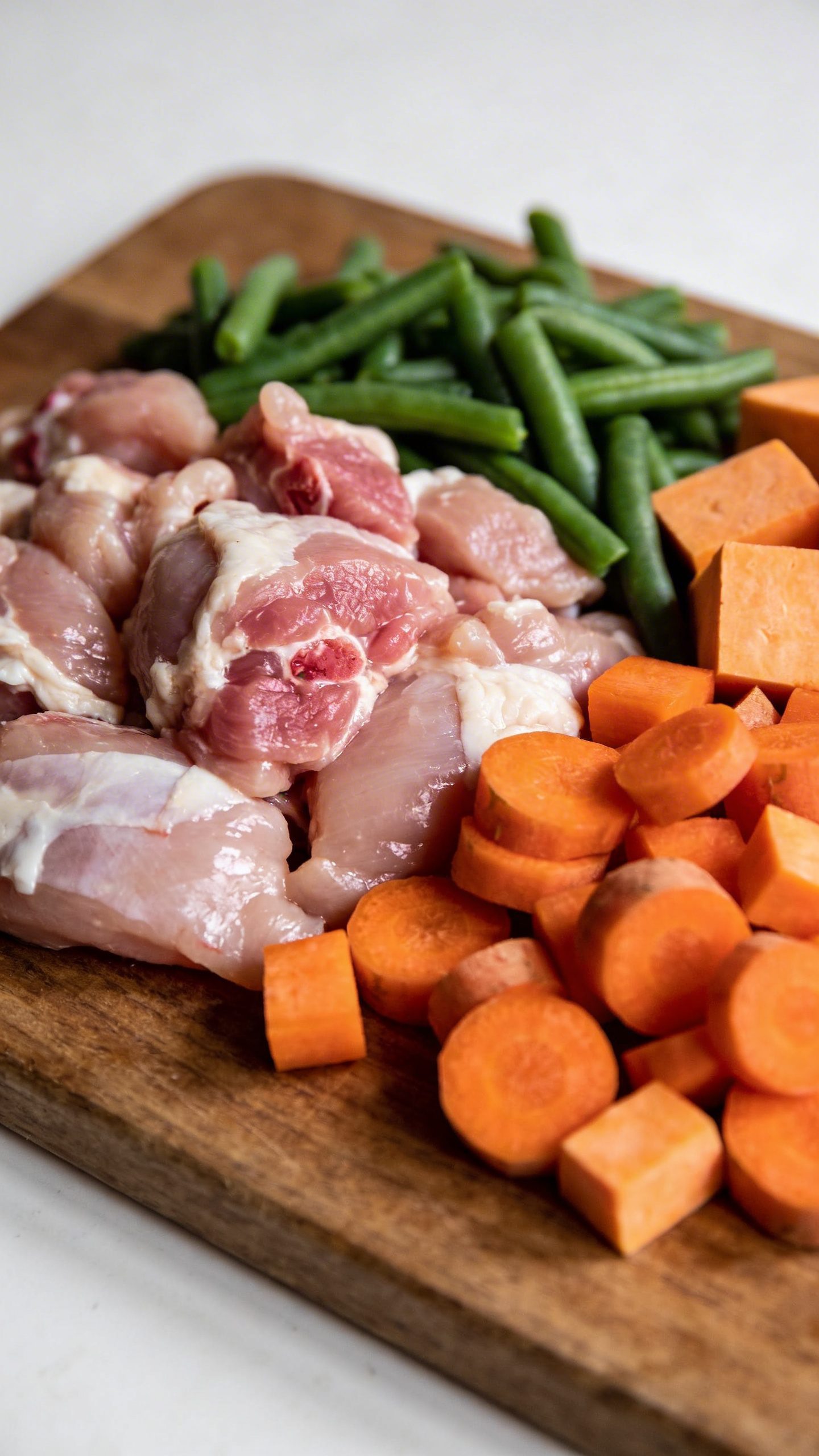 Raw chicken and vegetables for dog food prep