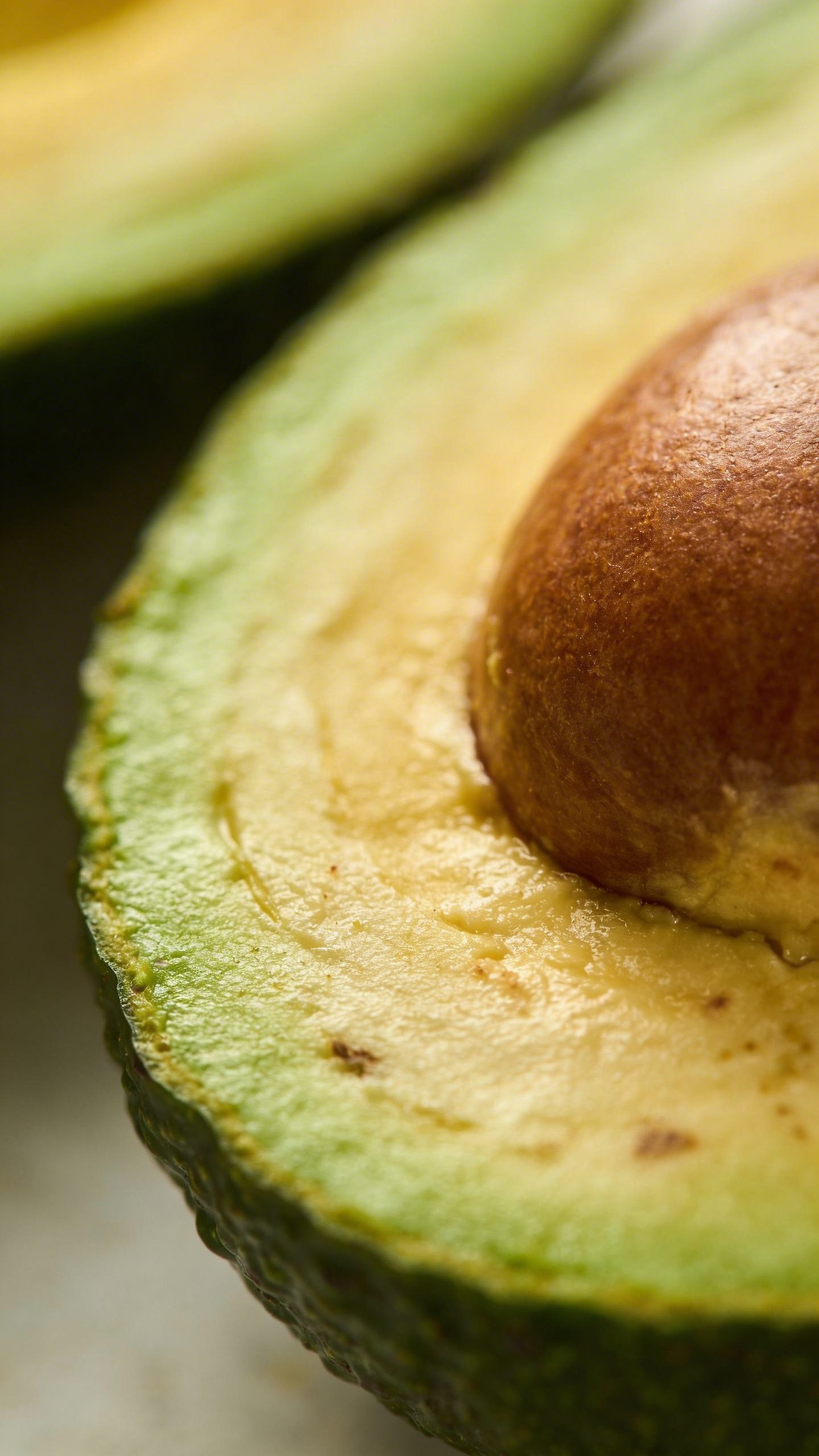 Halved avocado showing pit and flesh closeup