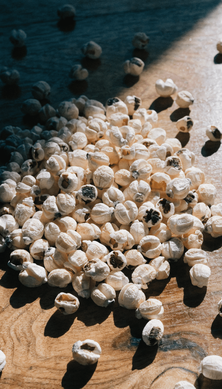 "Unpopped popcorn kernels on wooden table"