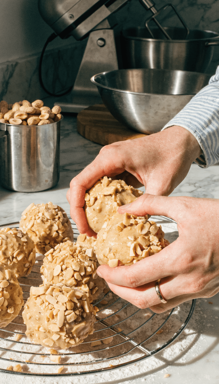 "Modern kitchen, hands shaping treats with peanut butter"